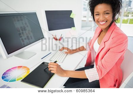 Portrait of a casual female photo editor using computer in a bright office