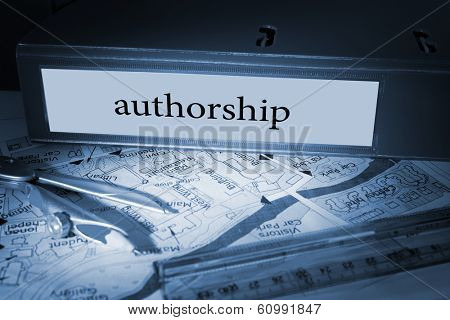 The word authorship on blue business binder on a desk