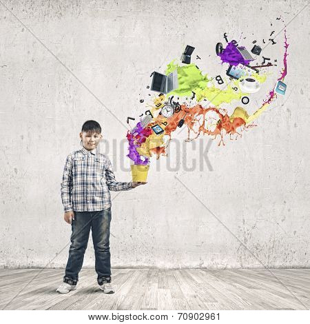Young boy splashing colorful paint from bucket