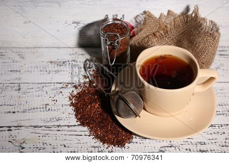 Cup of tasty rooibos tea, on old white wooden table