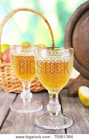 Still life with tasty apple cider and fresh apples, on nature background