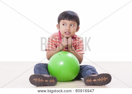 Cute little boy playing green ball
