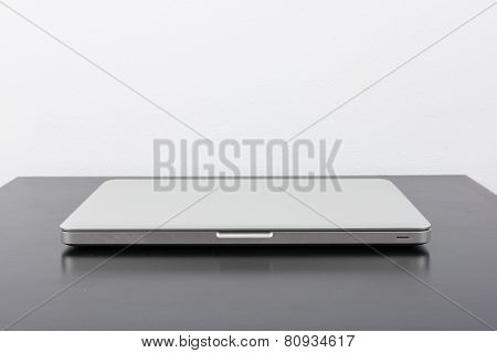 Laptop And Flower Pot On Black Wooden Table