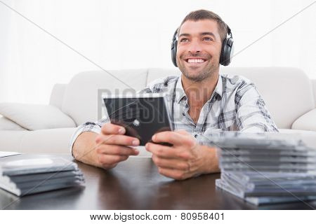 A man listening to cds at home in the living room