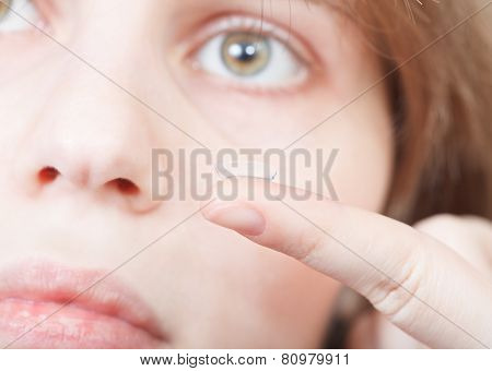 Finger With Corrective Lens And Female Face