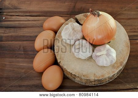 Eggs, Garlic, Onion On A Brown Wooden Table