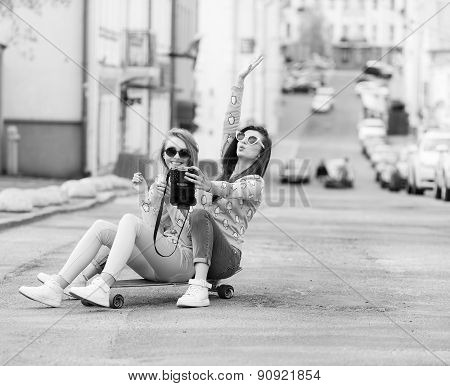 Hipster girlfriends taking a selfie in urban city context - Concept of friendship and fun with new t