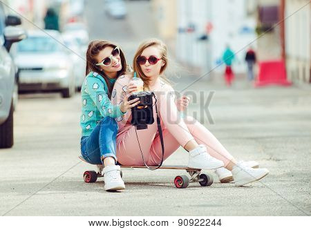 Hipster girlfriends taking a selfie in urban city context - Concept of friendship and fun with new t