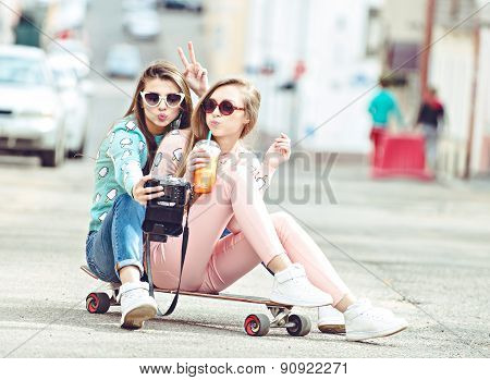 Hipster girlfriends taking a selfie in urban city context - Concept of friendship and fun with new t