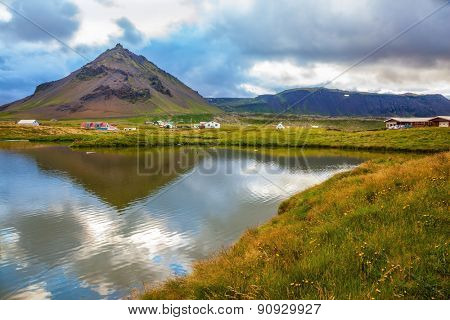 Evening light in the Polar region. Sunset in the fishing settlement of Arnastapi
