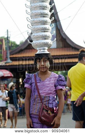 Mon girl carries pots on her head