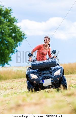 Woman driving off-road with quad bike or ATV