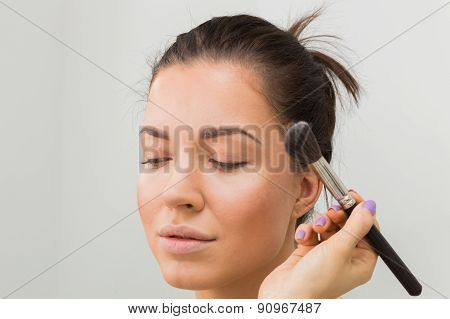 Application of powder on the model's face.