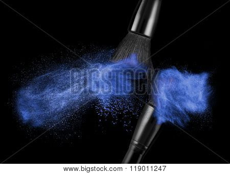 makeup brush with blue powder isolated on black