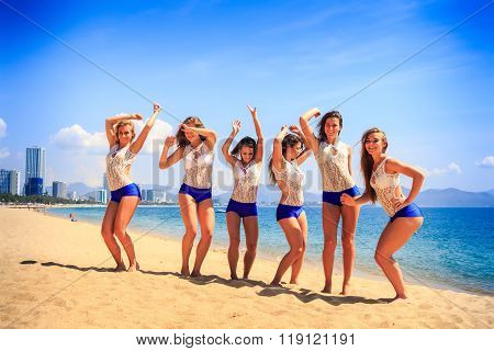 Cheerleaders Stand On Beach Laugh Wave Hands Against Azure Sea