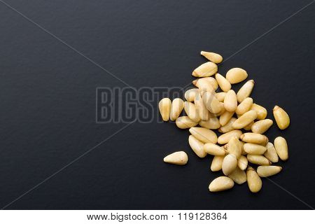 the pine nuts on black background