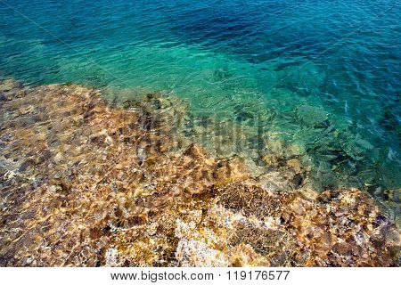Transparent clear water and stones with sunlight reflection