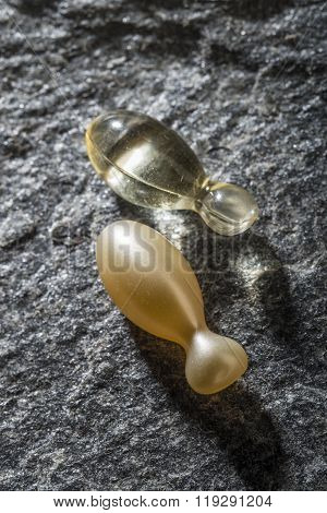 Transperent gel capsules on a stone background