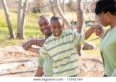 Szczęśliwy człowiek African American, kobieta i dziecko, zabawy w parku.