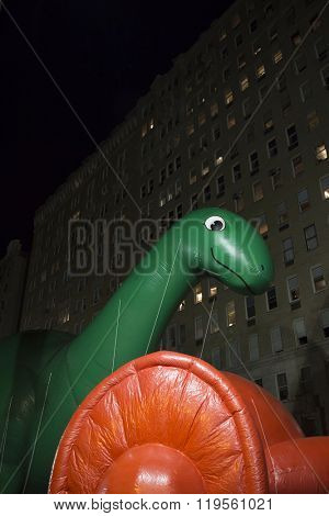 NEW YORK - NOV 25 2015: Dino, the green brontosaurus balloon from Sinclair Oil tied down during Macy's Giant Balloon Inflation event held the day before Thanksgiving in Manhattan.