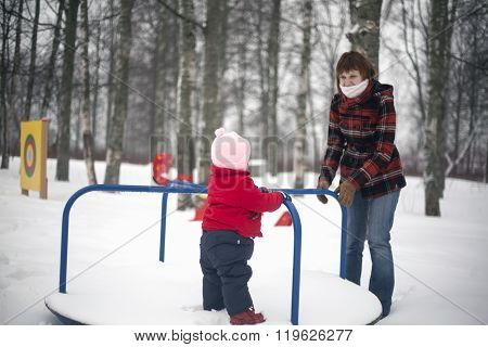 Mother Riding Her Little Child On Merry-go-round
