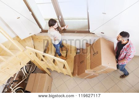 Young Couple Carrying The Boxes In New House