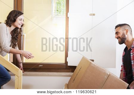 Young Couple Carrying The Boxes In New House