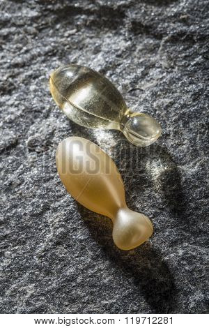Transperent gel capsules on a stone background