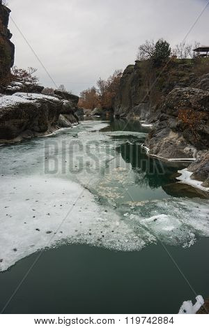 River With Green Waters, Snow And Ice Near Meteora In Greece