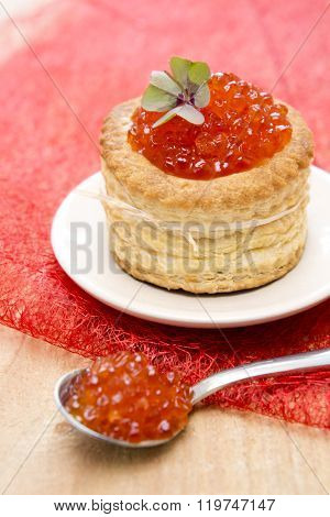 Tartlet with red caviar on plate.