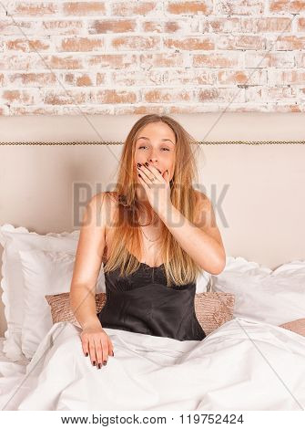 Young girl yawning in bed