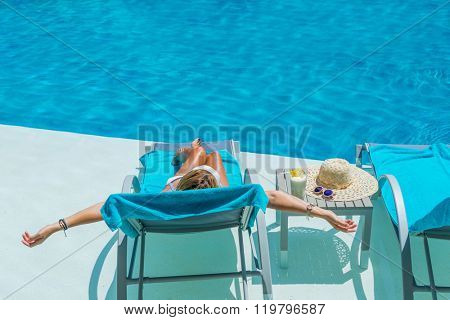 Pretty blond woman  enjoying a fresh cocktail in a swimming pool