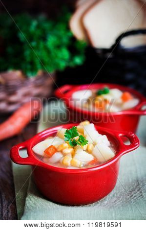 Chicken Noodle Soup With Vegetables In Red Bowl On Rustic Table