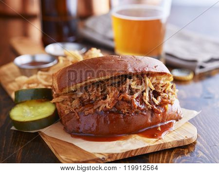barbecue pulled pork sandwich with beer in the background