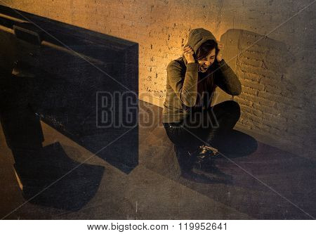 teen girl cyber abused suffering internet cyberbullying scared and desperate in fear face expression sitting in front of computer monitor in bullying social problem edgy grunge lighting