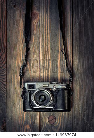 Retro film photo camera on the wooden background.