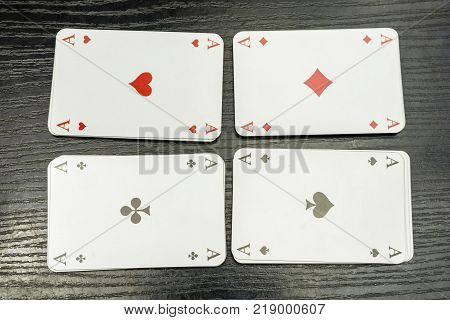 Four aces from a deck of playing cards on the table.