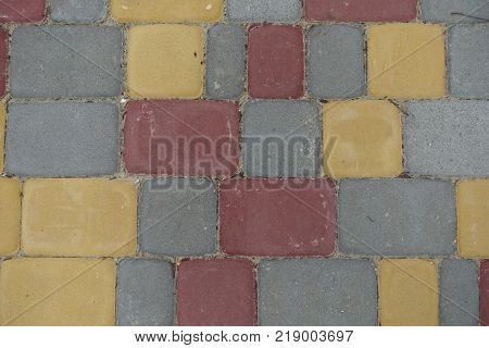 Red yellow grey concrete pavement blocks from above