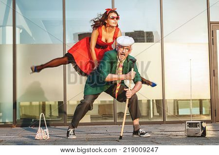 Woman jumps during a dance she dances with an old man.