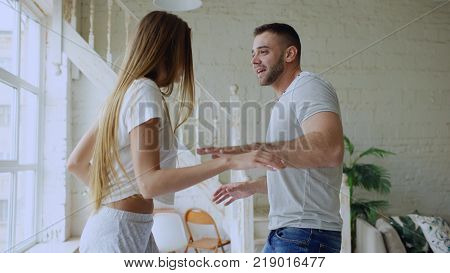 Young beautiful and loving couple dancing rocknroll dance on bed in morning at home