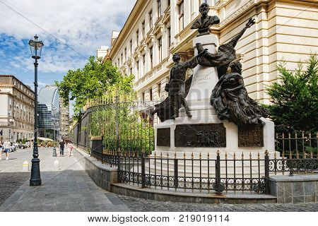 Bucharest, Romania - September 9, 2017: Tourists visiting the historical center Lipscani Street with its beautiful architecture, Bucharest, Romania. Monument to Eugeniu Carada in the foreground.