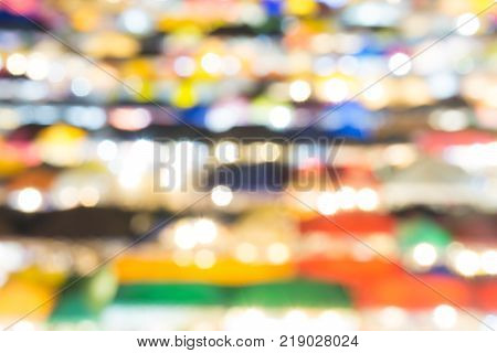 defocused of multi color light and plastic roof of ratchada train night marketbangkok. for christmas and new year abstract background concept.