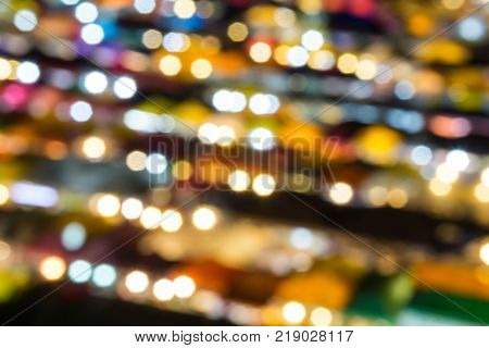 defocused of multi color light and plastic roof of ratchada train night marketbangkok. for christmas and new year abstract background concept.
