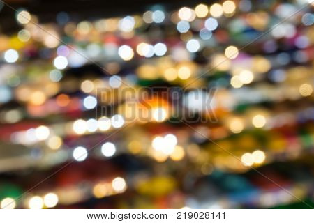 defocused of multi color light and plastic roof of ratchada train night marketbangkok. for christmas and new year abstract background concept.