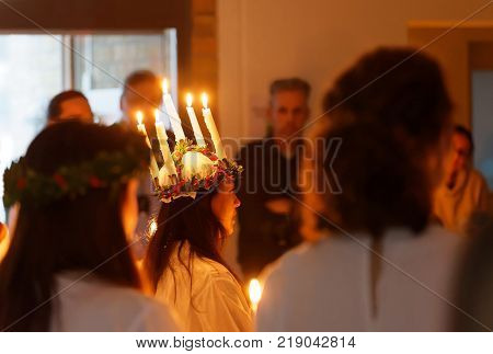 STOCKHOLM SWEDEN - DEC 13 2017: Lucia parade with singing girls and boys in white dresses holding candles. Traditional celebration of the suffering of saint Lucia from Italy in Stockholm Sweden December 13 2017