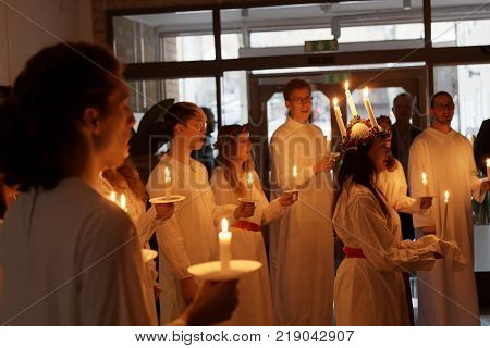 STOCKHOLM SWEDEN - DEC 13 2017: Lucia parade with singing girls and boys in white dresses holding candles. Traditional celebration of the suffering of saint Lucia from Italy in Stockholm Sweden December 13 2017