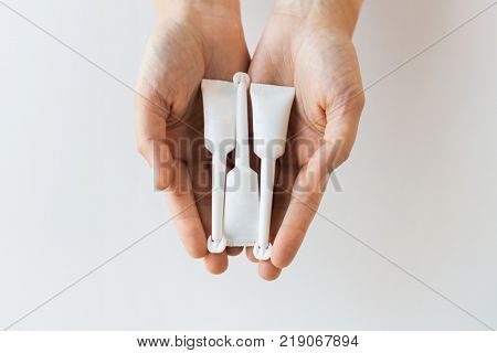 medicine, healthcare and pharmaceutics concept - hands holding tubes of micro enema