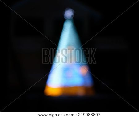 Defocused colorful blue christmas tree on darkness