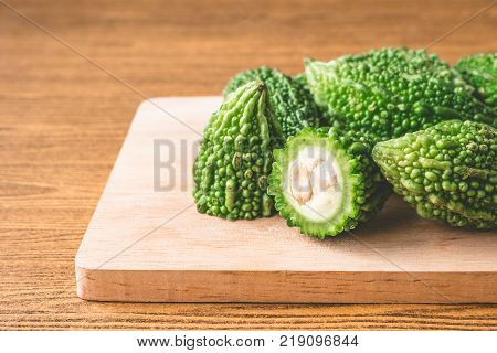 Bitter melon or bitter gourd on wooden tray. Free space for taxt