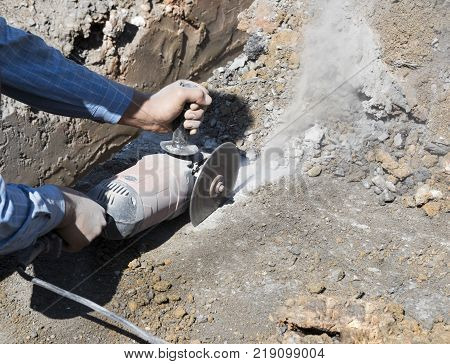 worker cut road by grinder ; close up